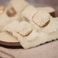 Side angle showcasing contoured cork-latex footbed and fluffy teddy shearling upper.