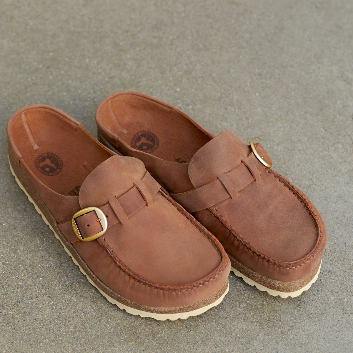 Overhead detail view of the Women's Birkenstock Buckley in Cognac oiled leather, a moccasin-style design with a unique integrated molded cork latex footbed for ultimate comfort and all day support.