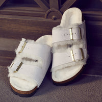 Front detail of the two-strap Birkenstock Arizona Shearling sandal in Antique White suede. Fully lined in genuine shearling over Birkenstock cork latex footbed.