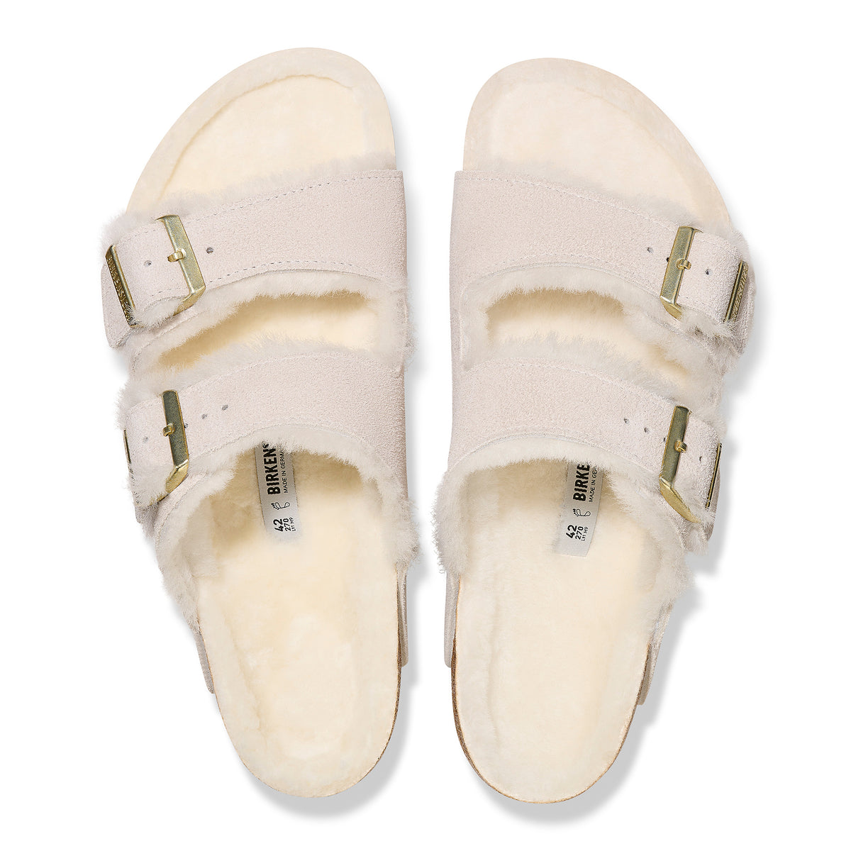 Top detail of the two-strap Birkenstock Arizona Shearling sandal in Antique White suede. Fully lined in genuine shearling over Birkenstock cork latex footbed with gold buckle hardware.