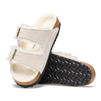 Detail side and bottom of the two-strap Birkenstock Arizona Shearling sandal in Antique White suede. Fully lined in genuine shearling over Birkenstock cork latex footbed.