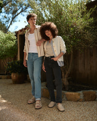 Two people outdoors styled in fall layers wearing Birkenstock Boston Shearling Clog and Arizona Shearling in Taupe, casual backyard setting