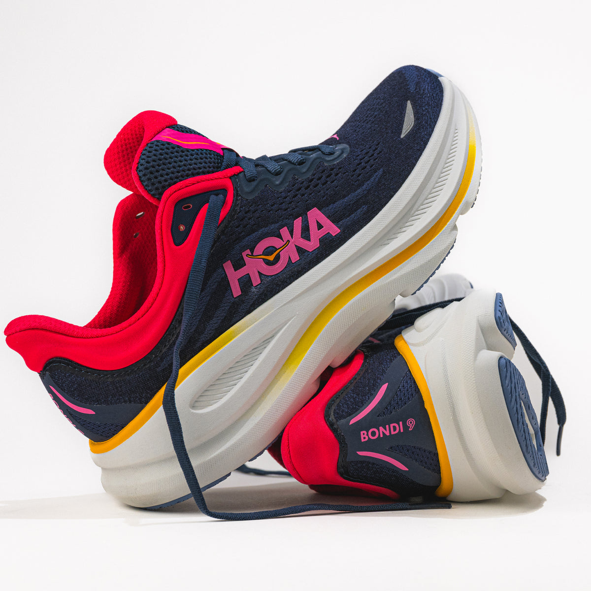 Navy, red, and white running shoes with 'Hoka' branding on a light background.
Women's HOKA Bondi 9 Running Shoe in Varsity Navy/Nautical Dusk