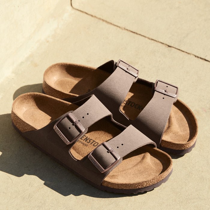 Side profile of the Birkenstock Arizona in Mocha Birkibuc, showing two adjustable straps and a cork-latex footbed.