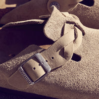 Detail view of the boho-inspired braided Birkenstock Boston Braid in Taupe suede. Classic suede upper with a braided sophisticated strap resting on the Birkenstock original contoured footbed