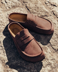 Pair of brown slip-on clogs on a textured stone surface
Birkenstock Naples Clog Wrapped in Habana Oiled Leather