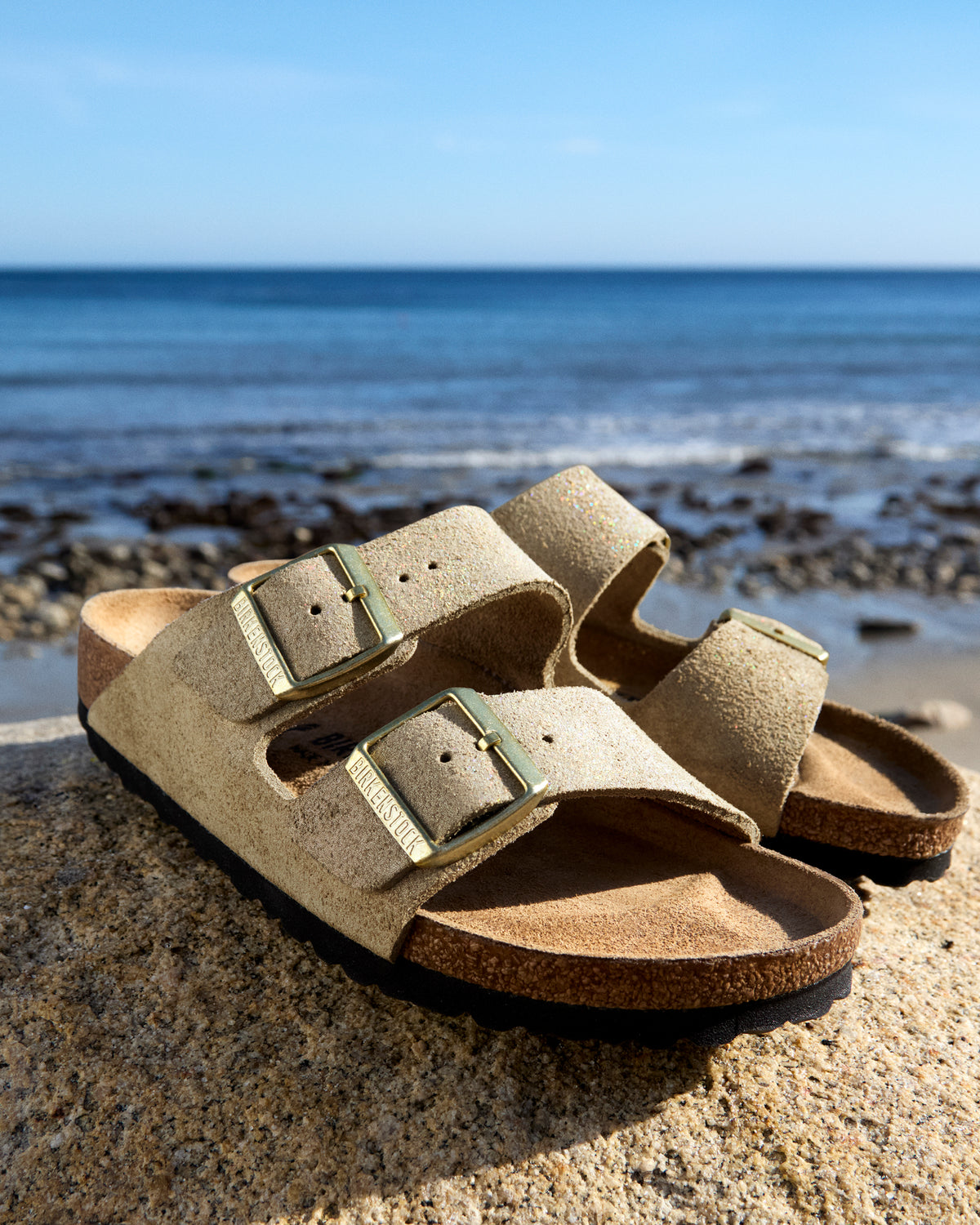 Birkenstock Arizona Sandal in Shimmering Taupe Suede.
Birkenstock Arizona sandal, shimmering taupe suede, iconic two-strap sandal, women’s comfort sandals, cork footbed sandals.