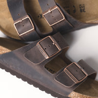 Close-up of the front view of the Birkenstock Arizona Sandal in Habana Oiled Leather, showcasing the iconic dual-strap design with adjustable metal buckles.