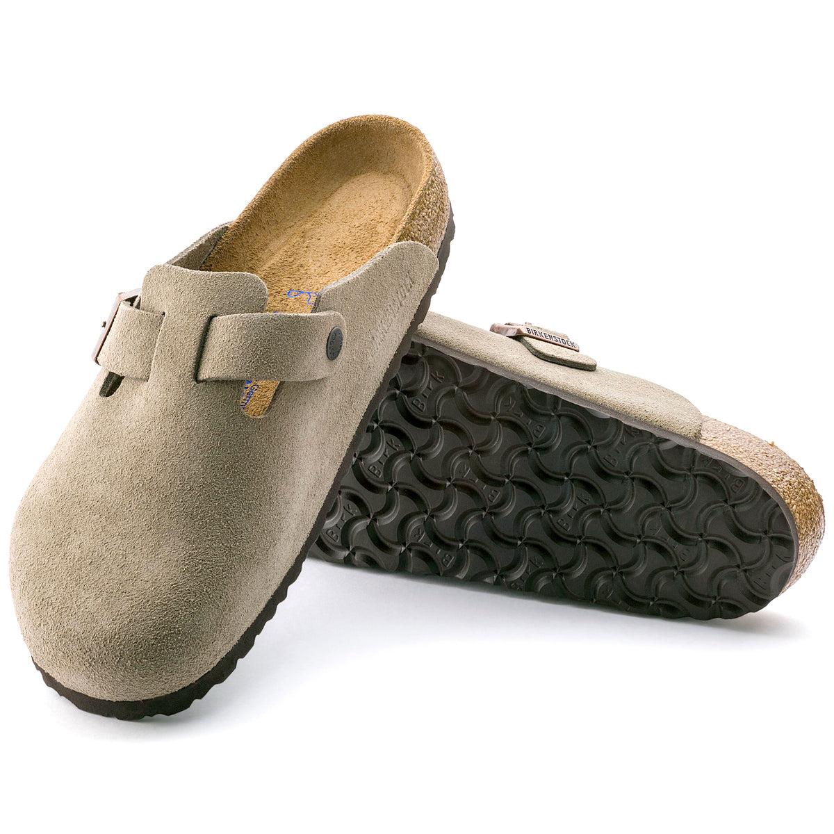 Pair of beige suede clogs with black soles on a white background.
Birkenstock Boston Soft clog in Taupe Suede, featuring premium suede leather for all-day comfort. Classic slip-on style with soft footbed support. Durable, lightweight, and built for long-lasting use, perfect for men and women seeking comfort and trendiness in footwear.