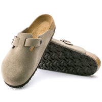 Pair of beige suede clogs with black soles on a white background.
Birkenstock Boston Soft clog in Taupe Suede, featuring premium suede leather for all-day comfort. Classic slip-on style with soft footbed support. Durable, lightweight, and built for long-lasting use, perfect for men and women seeking comfort and trendiness in footwear.