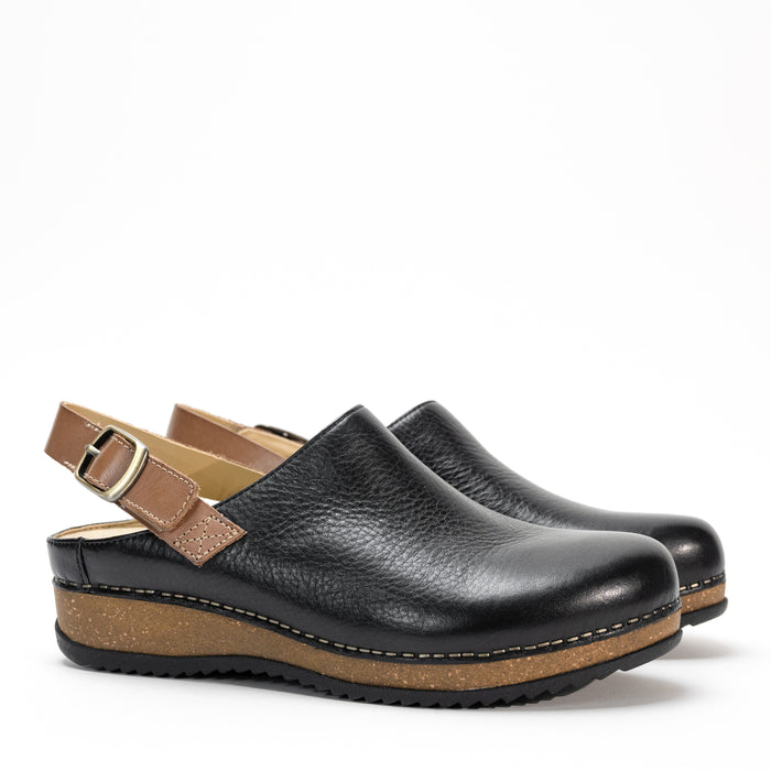 Side profile of the Dansko Merrin mule in high-quality leather, featuring a sleek sling-back strap and cork midsole.