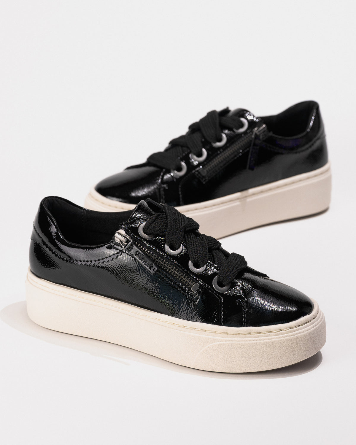 Three-quarter front view of the black patent Aetrex Aubrey platform sneakers