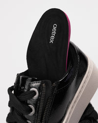 Close-up of removable Aetrex arch-support insole being pulled out of shoe