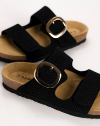 Close-up of oversized buckle detail on Naot Miami sandal on a white background