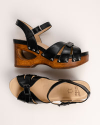 The Dansko Alanna in Black leather is a standout piece from Dansko’s Ashland collection, designed for those who want a high-fashion silhouette without the usual discomfort of a tall heel. Every pair is handmade in Brazil, featuring a genuine wood wedge that has been hand-carved, sanded, and flame-burnished for a one-of-a-kind finish. The sculpted 3.5-inch heel is balanced by a 1.5-inch platform, creating a manageable 2-inch effective slope that provides height while maintaining stability.