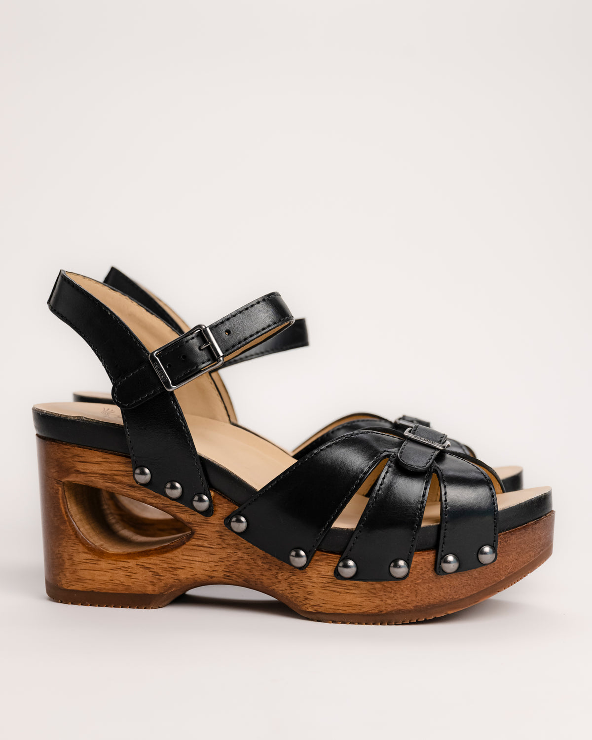 The Dansko Alanna in Black leather is a standout piece from Dansko’s Ashland collection, designed for those who want a high-fashion silhouette without the usual discomfort of a tall heel. Every pair is handmade in Brazil, featuring a genuine wood wedge that has been hand-carved, sanded, and flame-burnished for a one-of-a-kind finish. The sculpted 3.5-inch heel is balanced by a 1.5-inch platform, creating a manageable 2-inch effective slope that provides height while maintaining stability.