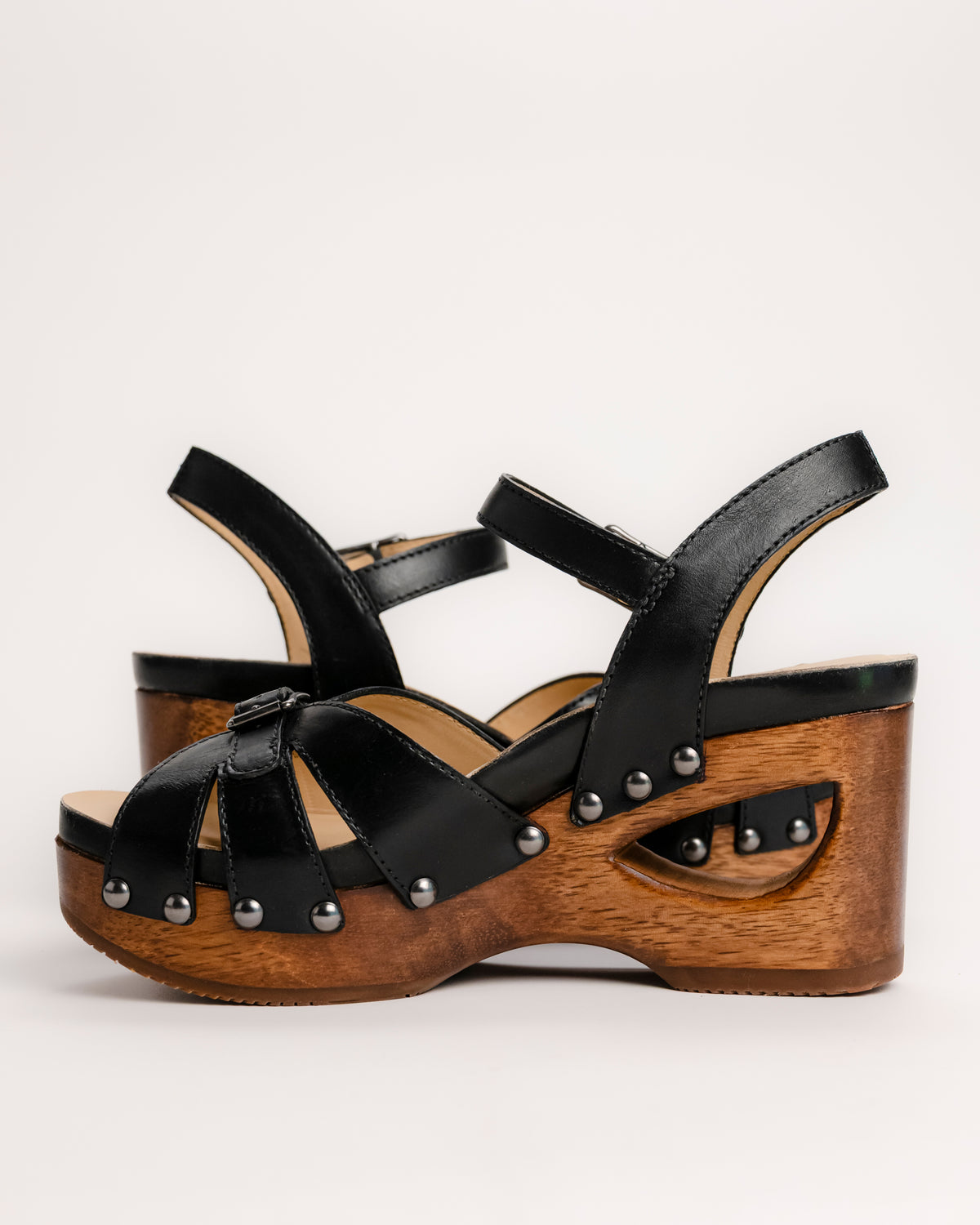 The Dansko Alanna in Black leather is a standout piece from Dansko’s Ashland collection, designed for those who want a high-fashion silhouette without the usual discomfort of a tall heel. Every pair is handmade in Brazil, featuring a genuine wood wedge that has been hand-carved, sanded, and flame-burnished for a one-of-a-kind finish. The sculpted 3.5-inch heel is balanced by a 1.5-inch platform, creating a manageable 2-inch effective slope that provides height while maintaining stability.