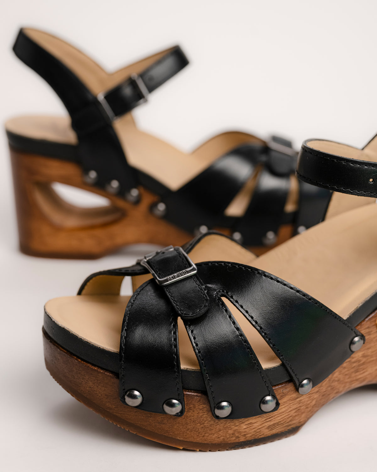 The Dansko Alanna in Black leather is a standout piece from Dansko’s Ashland collection, designed for those who want a high-fashion silhouette without the usual discomfort of a tall heel. Every pair is handmade in Brazil, featuring a genuine wood wedge that has been hand-carved, sanded, and flame-burnished for a one-of-a-kind finish. The sculpted 3.5-inch heel is balanced by a 1.5-inch platform, creating a manageable 2-inch effective slope that provides height while maintaining stability.
