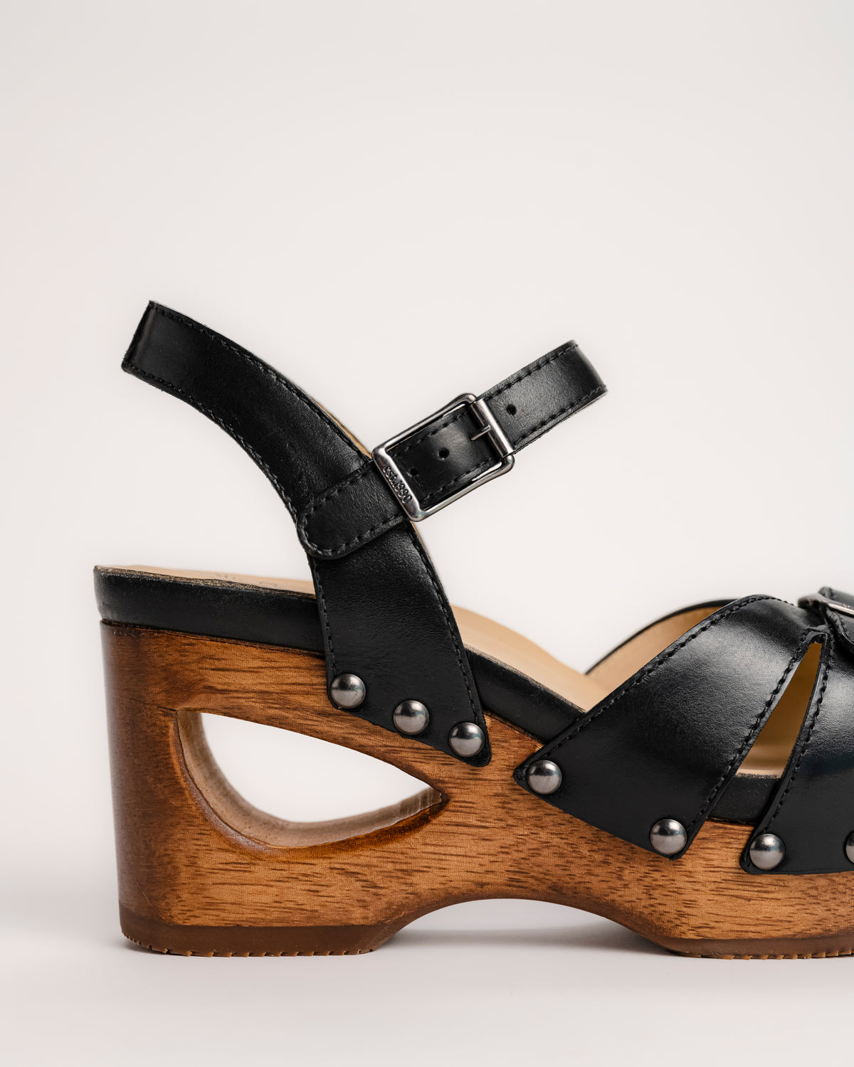 The Dansko Alanna in Black leather is a standout piece from Dansko’s Ashland collection, designed for those who want a high-fashion silhouette without the usual discomfort of a tall heel. Every pair is handmade in Brazil, featuring a genuine wood wedge that has been hand-carved, sanded, and flame-burnished for a one-of-a-kind finish. The sculpted 3.5-inch heel is balanced by a 1.5-inch platform, creating a manageable 2-inch effective slope that provides height while maintaining stability.