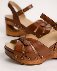 The Dansko Alanna in Tan leather is a standout piece from Dansko’s Ashland collection, designed for those who want a high-fashion silhouette without the usual discomfort of a tall heel. Every pair is handmade in Brazil, featuring a genuine wood wedge that has been hand-carved, sanded, and flame-burnished for a one-of-a-kind finish. The sculpted 3.5-inch heel is balanced by a 1.5-inch platform, creating a manageable 2-inch effective slope that provides height while maintaining stability.
