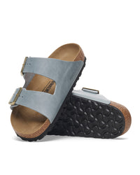 Pair of light blue Basalt colored Birkenstock Arizona two-strap sandals with cork-latex contoured footbed and golden buckles on a white background