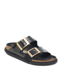 Black sandal with gold droplet-styled buckles on a white background