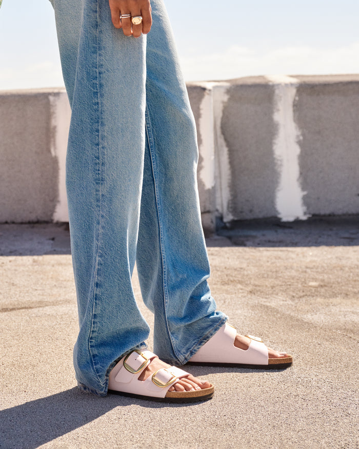 The Birkenstock Arizona Big Buckle in Light Rose Birkibuc bridges the gap between high-fashion aesthetics and everyday durability. This edition updates the legendary two-strap sandal with an amplified, oversized metal buckle that acts as a striking centerpiece. The upper is crafted from light pink-colored Birkibuc, a skin-friendly, durable synthetic material that perfectly mimics the soft texture and matte finish of nubuck leather.