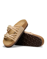 The Birkenstock Granada offers a refined, natural aesthetic for those who appreciate the support of a classic slide but want a more detailed look. This version is upgraded with premium nubuck leather, which is gently buffed to create a soft, velvety texture that feels luxurious from the first wear. The twin-strap design features elegant laser-cut perforations, providing a light and airy feel that transitions perfectly from a casual day out to a more put-together summer evening.