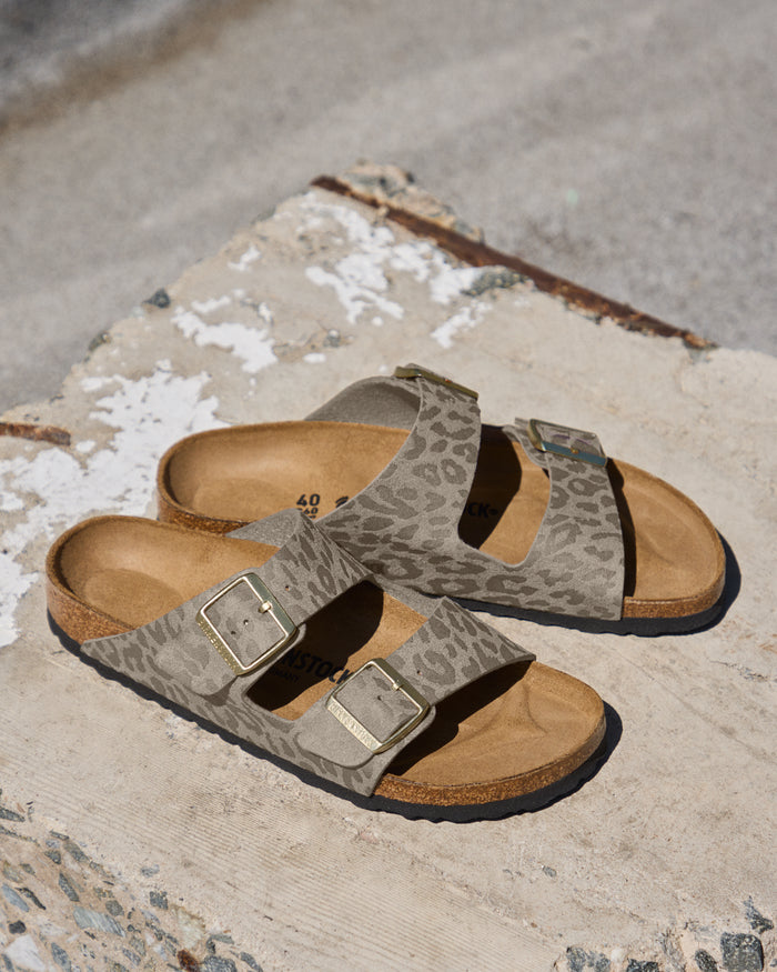 The Birkenstock Arizona Leopard Print Sandal in Birko-Flor brings a fierce, fashion-forward twist to the iconic style. This edition wraps the legendary two-strap silhouette in a bold, untamed animal print that serves as a neutral for any wardrobe. It instantly adds a pop of pattern to denim, linen, or monochrome outfits. The upper is crafted from synthetic textured Birko-Flor, a skin-friendly and tear-resistant synthetic material that offers a sleek, leather-like finish. 
