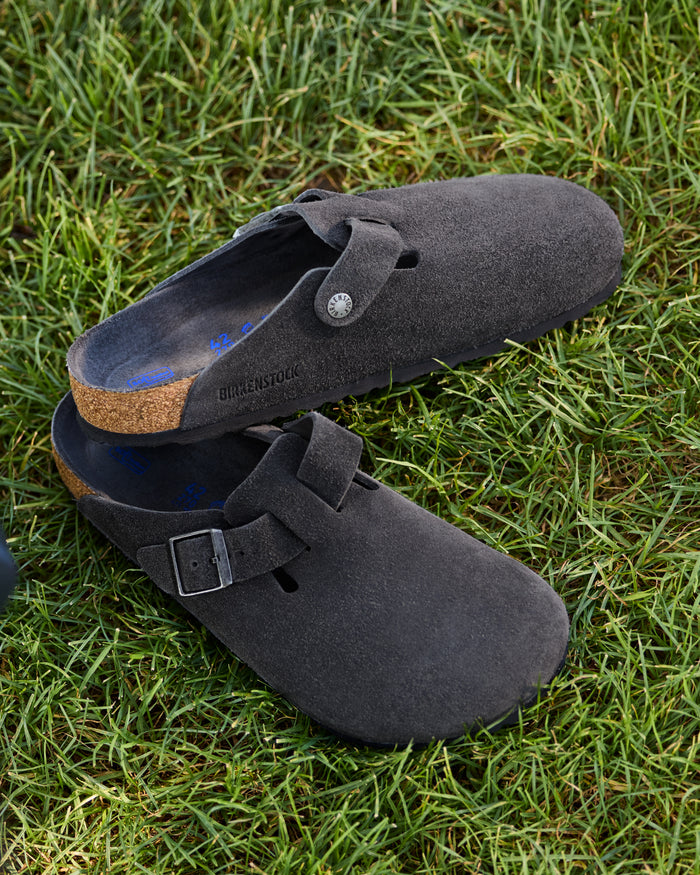 Birkenstock Boston Soft Footbed Suede Leather Clog in Charcoal

The Birkenstock Boston Clog has transitioned from a lounge staple to a street-style icon, and this version offers the most "broken-in" feel right out of the box. Crafted from premium, velvety suede, the upper has a soft, flexible drape that conforms comfortably to the foot. The standout feature is the integrated latex foam layer tucked inside the signature cork footbed. This "soft footbed" provides instant cushioning.