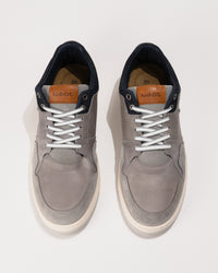 Pair of gray sneakers with white laces on a white background