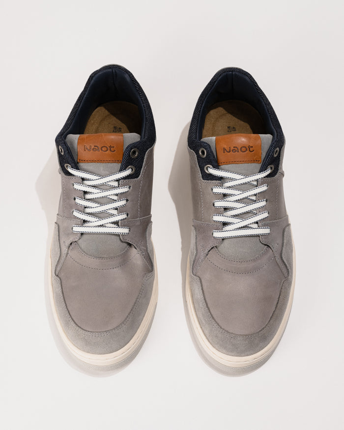 Pair of gray sneakers with white laces on a white background