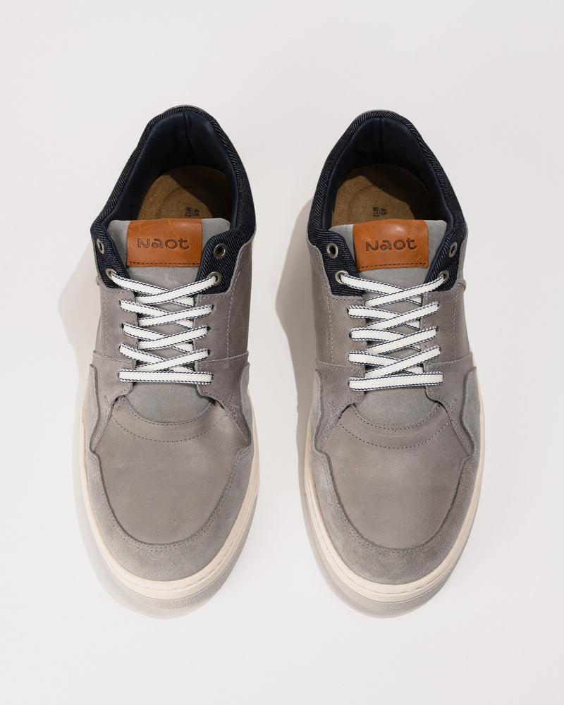 Pair of gray sneakers with white laces on a white background