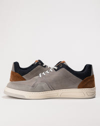 Gray sneaker with brown and navy accents on a light background