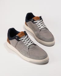 Pair of gray sneakers with white laces on a white background