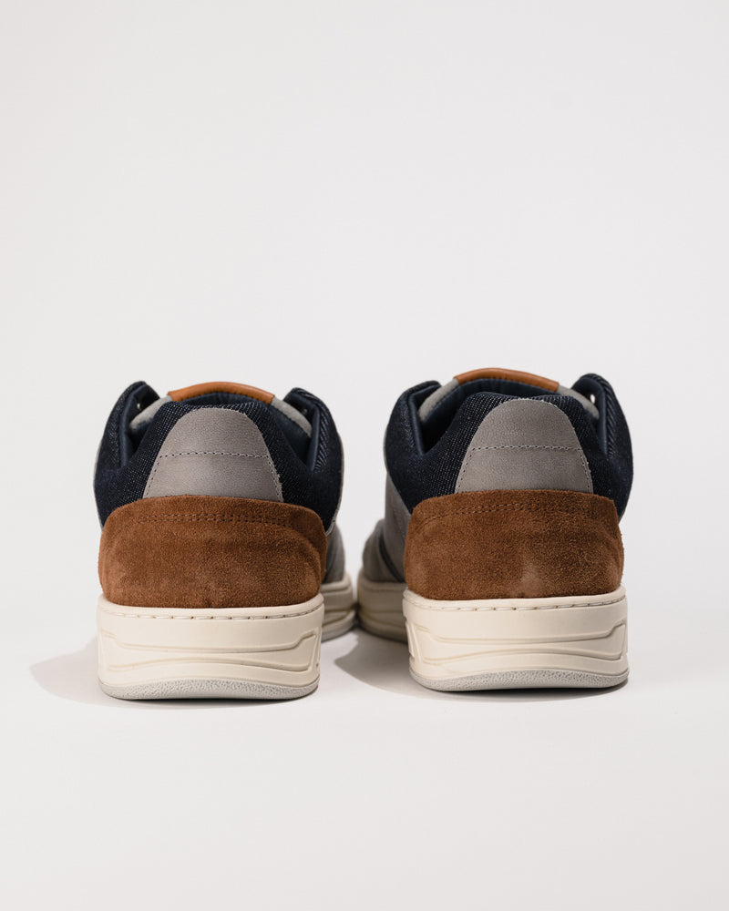 Pair of sneakers with brown and navy design on a light gray background