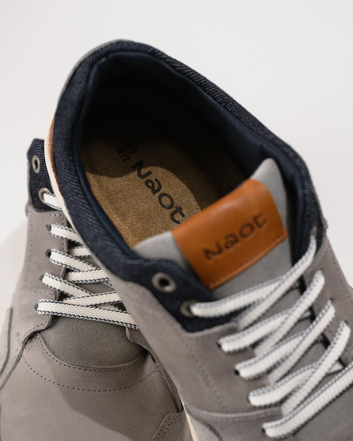 Naot Gray sneaker with white laces and brown removable arch footbed on a light background