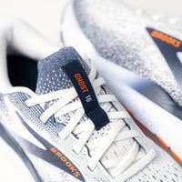 Close-up of the Brooks logo and stylish details on the Ghost 16 in White/Peacoat accents.