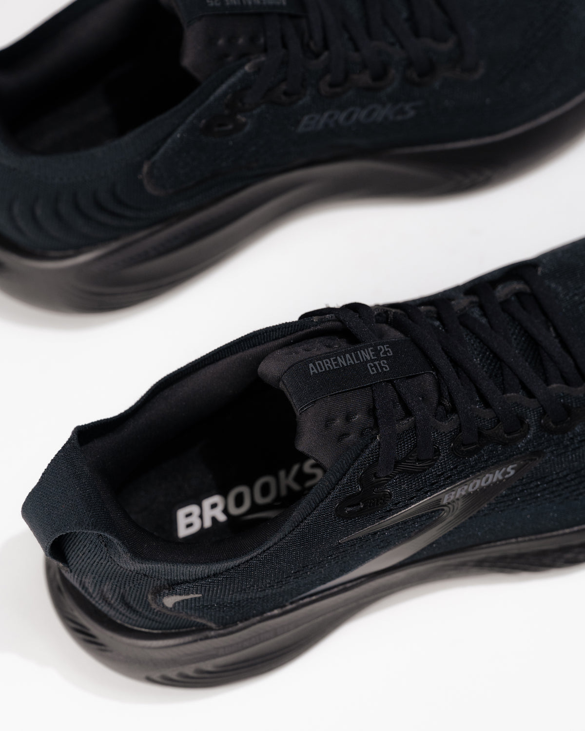 Close-up of Brooks Adrenaline GTS 25 logo and medial side detail – men’s stability running shoe in all-black colorway
