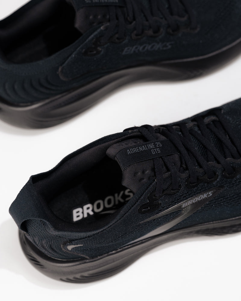 Close-up of Brooks Adrenaline GTS 25 logo and medial side detail – men’s stability running shoe in all-black colorway
