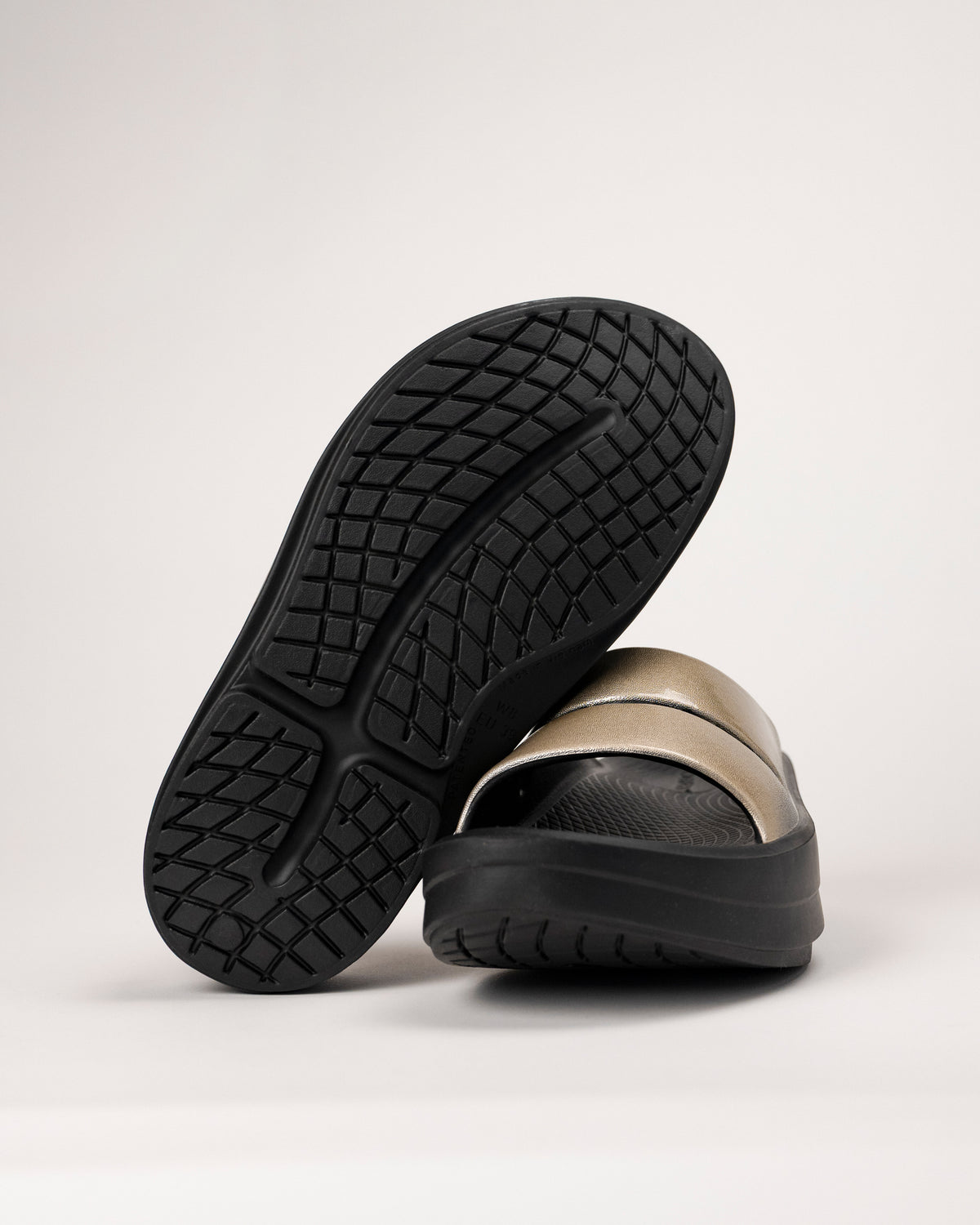 Bottom view of the OOFOS Luxe Slide showing traction pattern