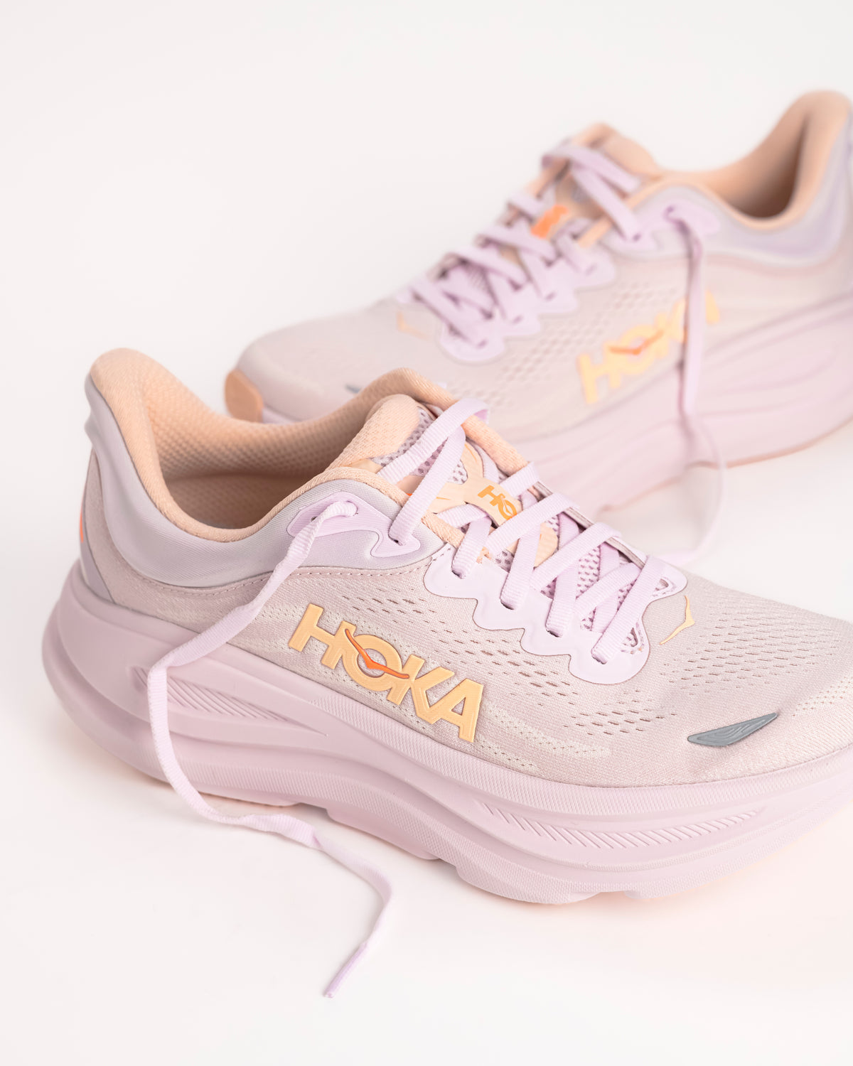 Women’s HOKA Bondi 9 – Max-Cushioned Running Shoe in Lilac Cream / Tangerine, Peachy Pink colorway with bright tangerine accents. 1162012-LRMT