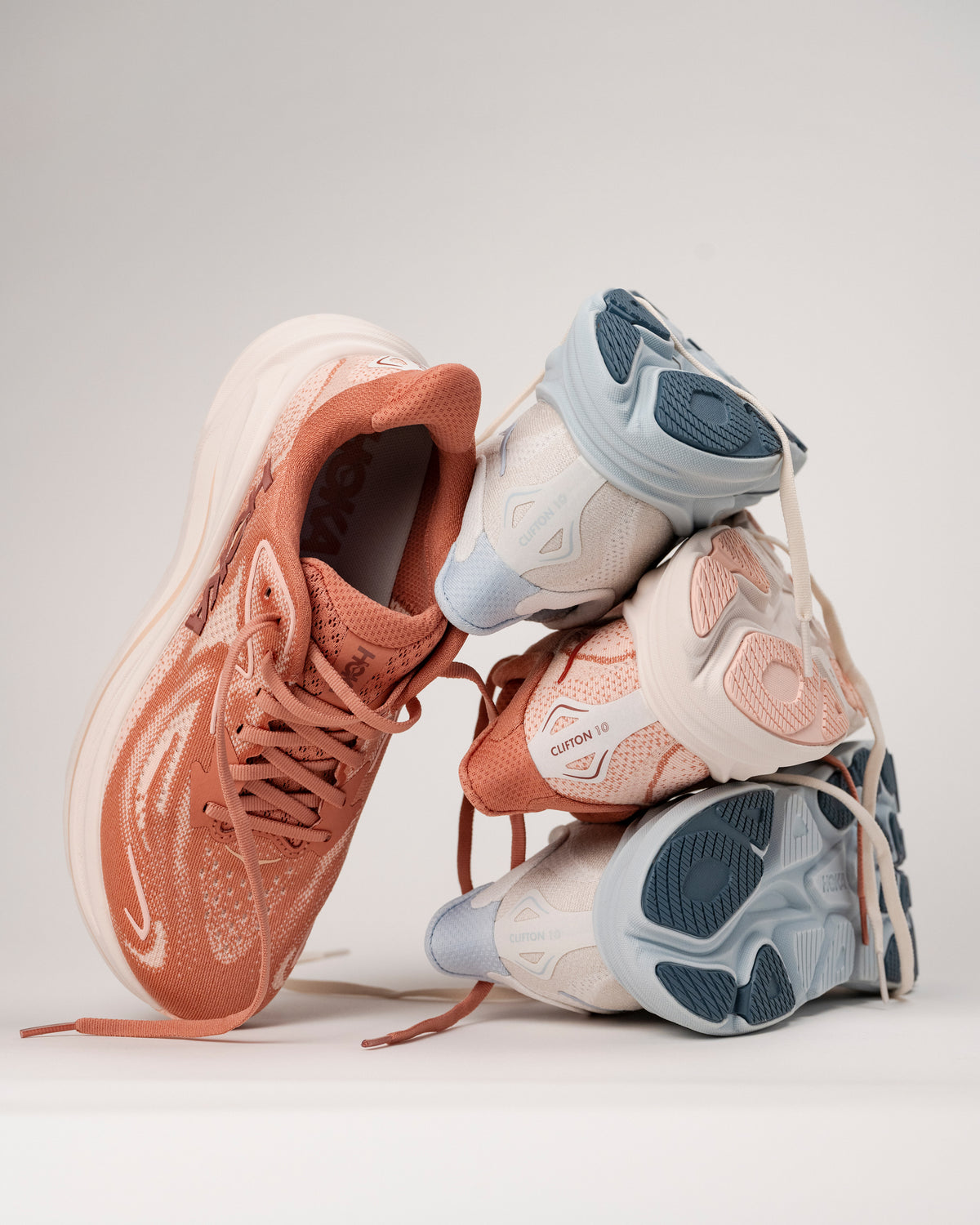 New colors of HOKA Clifton 10 running shoes for women stacked on each other on a white background