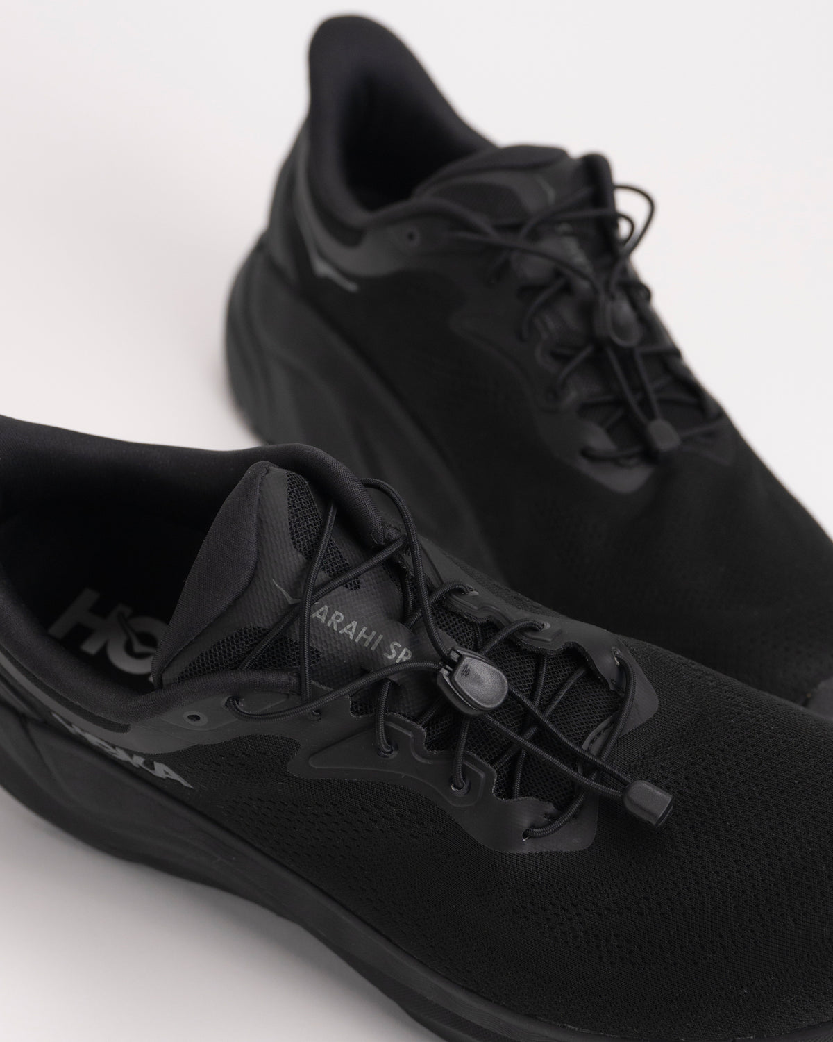 Detail view of the Men's HOKA Arahi SR easy-on toggle lace design.