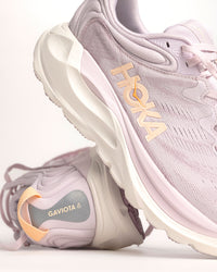 The Women’s HOKA Gaviota 6 is designed for runners and walkers who want dependable stability paired with plush, confidence-building comfort. Built on a broad, cushioned platform, this supportive road running shoe delivers a smooth, balanced ride that feels steady underfoot without feeling stiff or restrictive. Lilac Cream / Fragrant Lilac