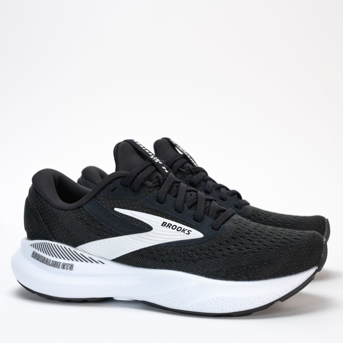 Women’s Brooks Adrenaline GTS 24 running shoe side view in sleek black and white, showcasing the nitrogen-infused DNA LOFT v3 cushioning and GuideRails® stability system.