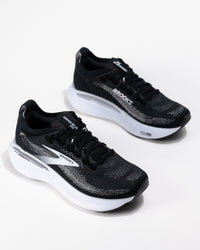 Dynamic angle of the Brooks Adrenaline GTS 25 in black/grey/white, a women's cushioned running shoe