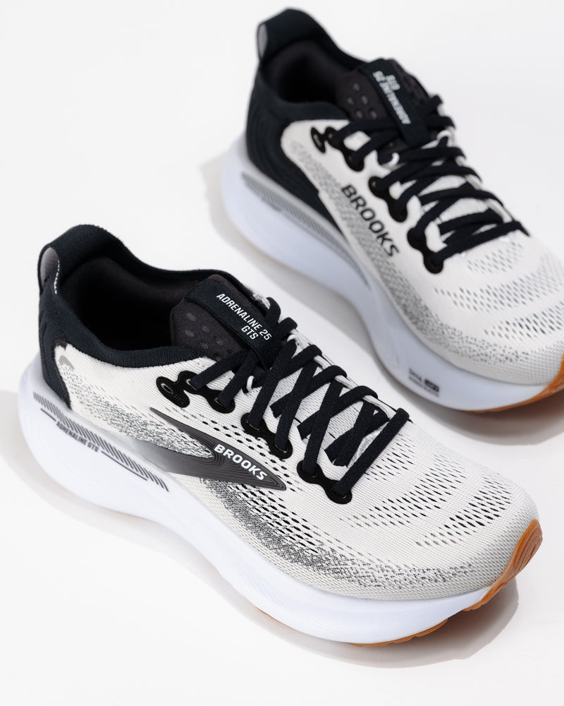 Three-quarter angle of Women's Brooks Adrenaline GTS 25 in White/Black/Gum, highlighting dual-density foam midsole and streamlined silhouette.