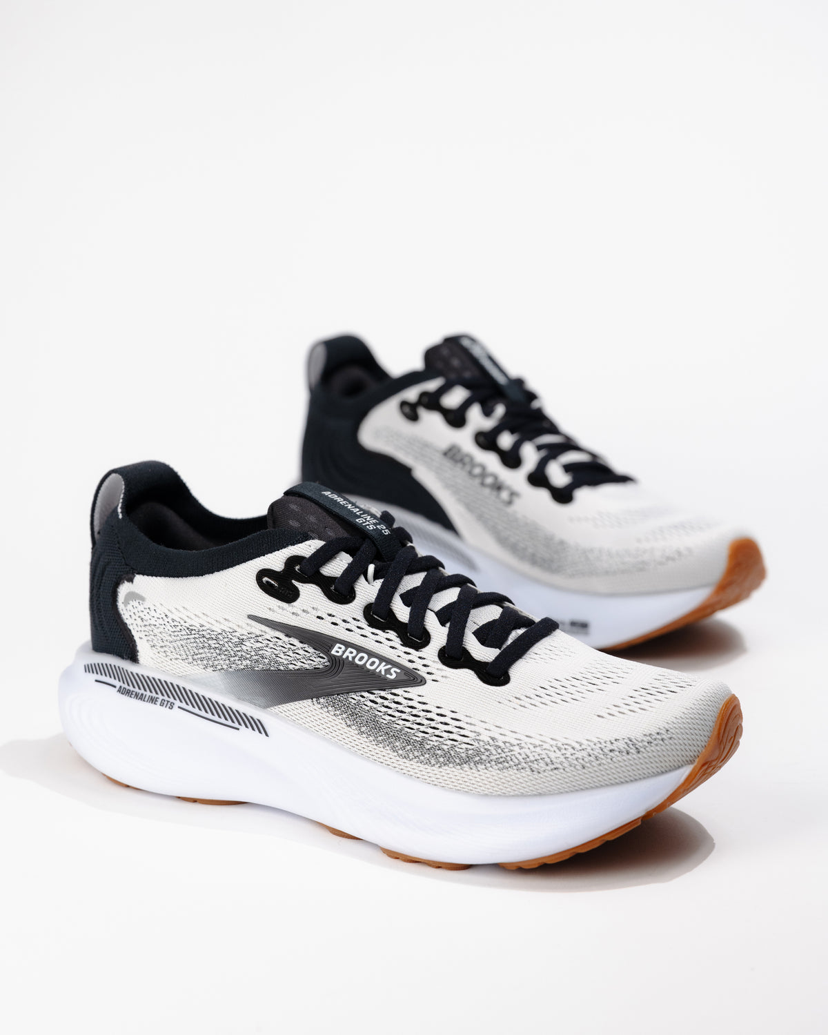 Three-quarter angle of Women's Brooks Adrenaline GTS 25 in White/Black/Gum, highlighting dual-density foam midsole and streamlined silhouette.