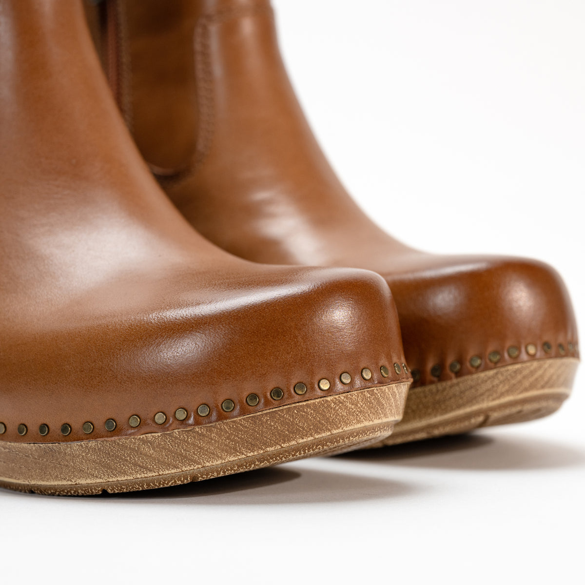 Close-up of the nail-head accents along the trim of the Dansko Shayna boot, highlighting the craftsmanship.